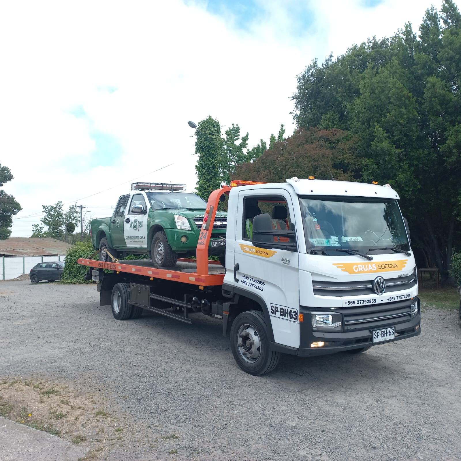 Grúa Socova trasladando una camioneta verde