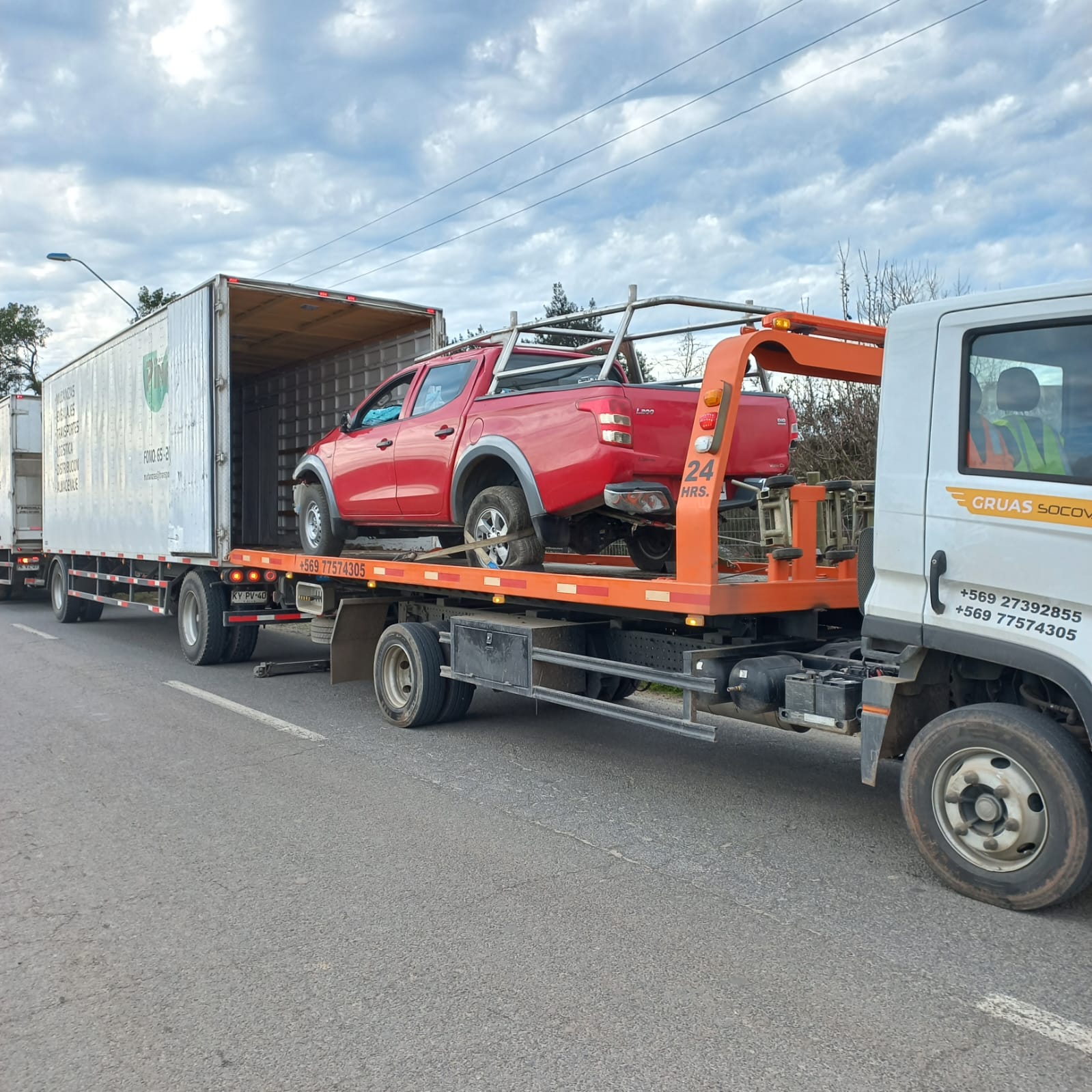 Grúa Socova trasladando una camioneta roja